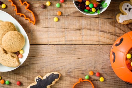 Téléchargez les photos : Biscuits et bonbons au pain d'épice halloween sur un fond en bois. - en image libre de droit