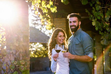 Téléchargez les photos : Jeune couple buvant du vin dans le vignoble - en image libre de droit