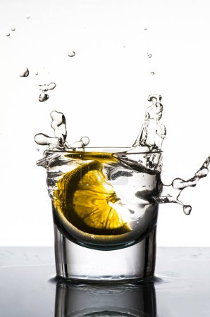 Téléchargez les photos : Éclaboussure de citron dans un verre sur fond blanc - en image libre de droit