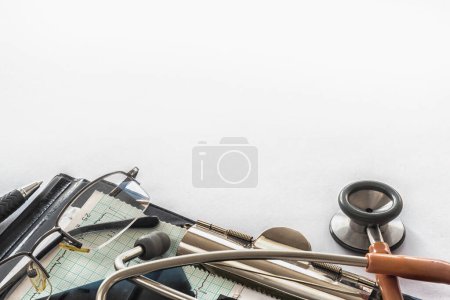 Foto de Escritorio del consultorio del médico con documentos médicos, cartas, anteojos y estetoscopio - Imagen libre de derechos