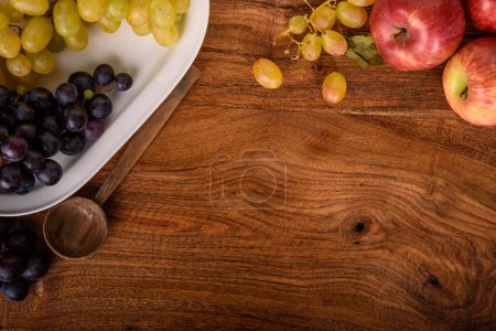 Téléchargez les photos : Pommes et raisins sur la table rustique en bois - en image libre de droit