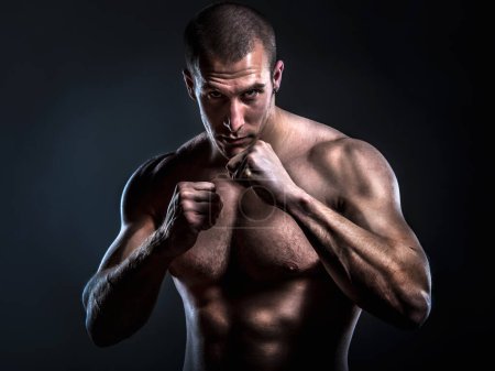 Photo for Handsome muscular man with naked torso posing on black background - Royalty Free Image