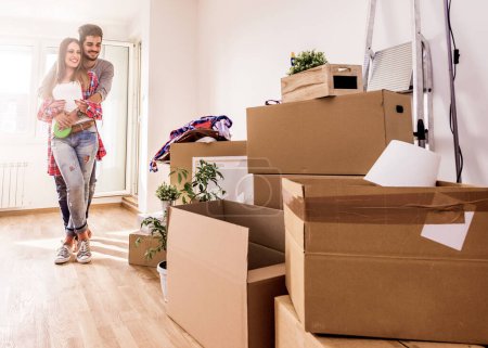 Téléchargez les photos : Jeune couple vient d'emménager dans un nouvel appartement vide déballer et nettoyer - déménagement - en image libre de droit