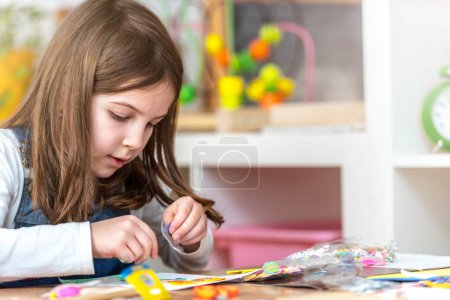 Photo for Little girl painting a paper with a colorful pattern - Royalty Free Image
