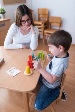 Photo for Proud mother looking at her son playing didactic games learning - Royalty Free Image