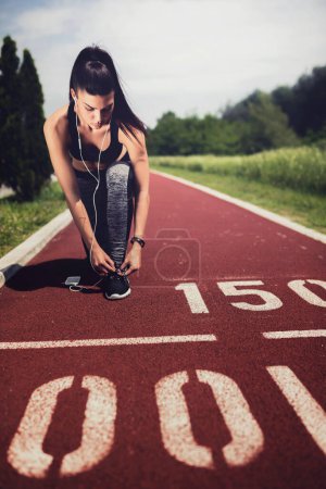 Photo for Athletic female athlete runner on stadium track - Royalty Free Image