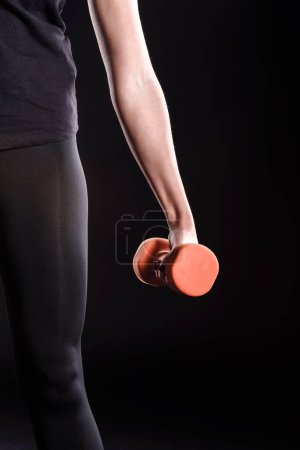 Photo for Sportswoman Lifting Dumbbell on background - Royalty Free Image