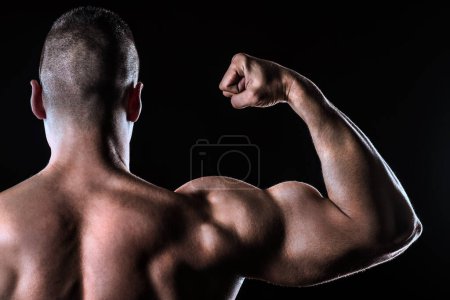 Photo for Handsome man with sporty body posing over black background - Royalty Free Image