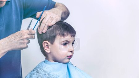 Téléchargez les photos : Garçon et son coiffeur dans le salon de coiffure - en image libre de droit