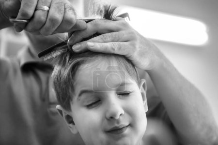 Foto de Niño y su peluquero en la peluquería - Imagen libre de derechos