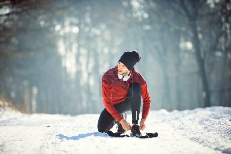 Foto de Hombre corredor preparándose para el entrenamiento en condiciones extremas de nieve - Imagen libre de derechos