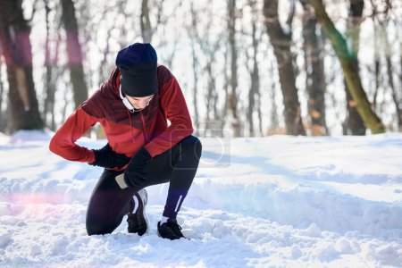 Téléchargez les photos : Homme coureur se préparant pour l'entraînement dans des conditions de neige extrêmes - en image libre de droit