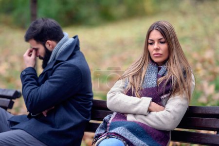 Couple assis dans le parc ayant des problèmes relationnels

