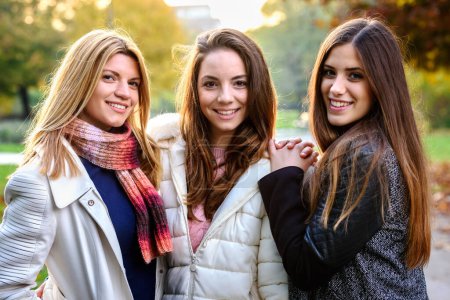 Foto de Grupo de chicas universitarias sonrientes caminando por el parque - amistad - Imagen libre de derechos