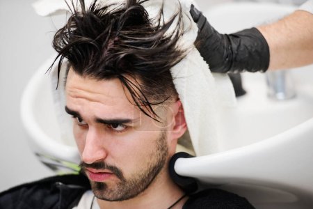 Téléchargez les photos : Homme se faisant laver les cheveux dans un salon de coiffure - en image libre de droit