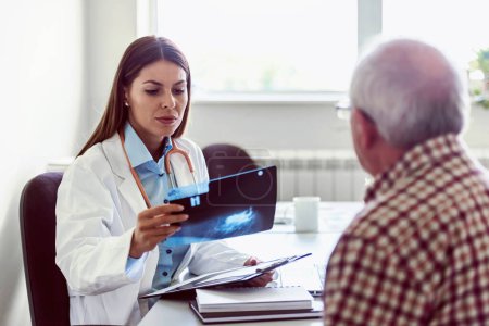 Photo for Doctor is examining a patient in clinic, checking xray - Royalty Free Image