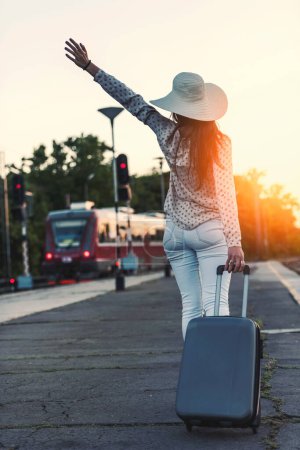 Foto de Mujer joven con equipaje caminando a la luz del sol. Fondo de viaje. - Imagen libre de derechos