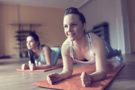 Téléchargez les photos : Jeune femme faisant des exercices dans la salle de gym - en image libre de droit
