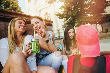 Foto de Grupo de amigos divirtiéndose junto a la fuente pública en el día de verano - Imagen libre de derechos