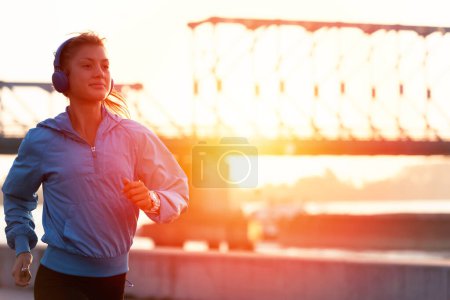 Foto de Joven corredora corriendo por el río por la mañana - Imagen libre de derechos