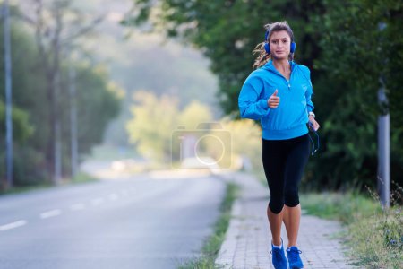 Photo for Urban woman jogger running by the road - Royalty Free Image