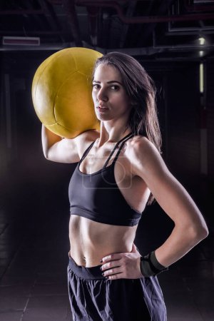 Foto de Fitness mujer deportiva sosteniendo la pelota de medicina suave en el interior. Detalle. - Imagen libre de derechos