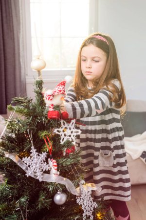 Foto de Hermosa niña decorando el árbol de Navidad - Imagen libre de derechos