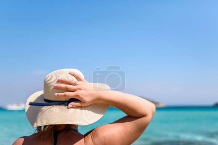 Foto de Mujer en sombrero en la playa, vista trasera - Imagen libre de derechos