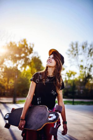 Photo for Cute urban girl holding longboard in skate park - Royalty Free Image