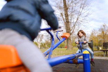 Photo for Little boy playing with girl in playground - Royalty Free Image