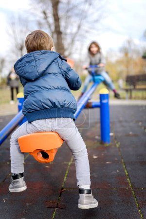 Photo for Little boy playing with girl in playground - Royalty Free Image