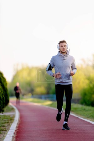 Téléchargez les photos : Homme jogging le matin sur la piste de course - en image libre de droit
