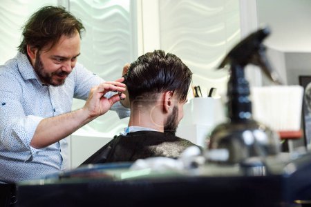 Téléchargez les photos : Homme ayant les cheveux taillés dans le salon de coiffure - en image libre de droit