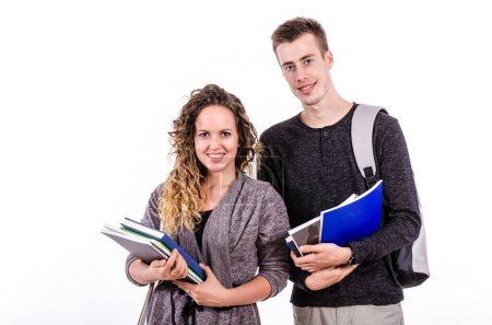 Téléchargez les photos : Couple d'étudiants avec des livres debout sur fond blanc - en image libre de droit