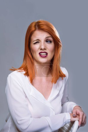 Photo for Red Hair Woman With one Eye Closed Funny Facial Expression - Royalty Free Image