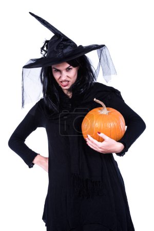 Foto de Hermosa joven bruja en traje de halloween negro celebración de calabaza - Imagen libre de derechos