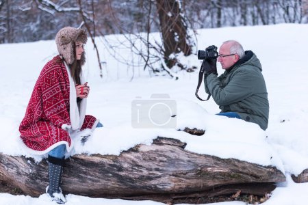 Foto de Una chica está tomando una foto de un muñeco de nieve en la nieve - Imagen libre de derechos