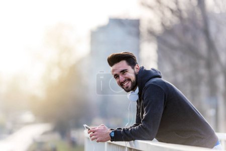 Foto de Man Jogger Con Auriculares Usando Smartphone y Escuchando Música - Imagen libre de derechos