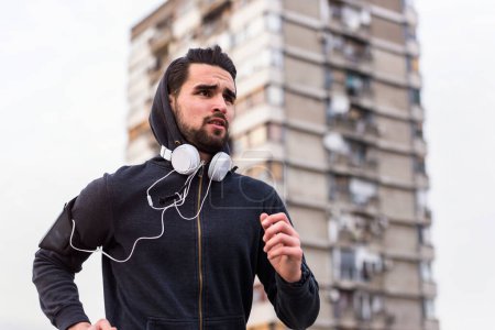 Téléchargez les photos : Jeune homme jogging dans la ville - en image libre de droit