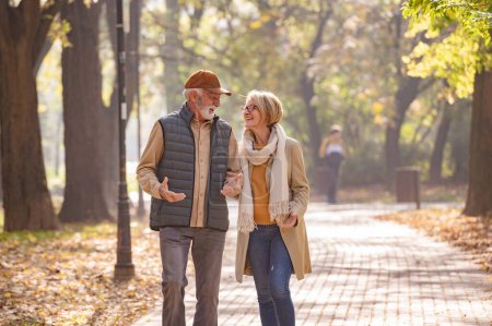 Téléchargez les photos : Heureux couple de personnes âgées marchant dans le parc d'automne - en image libre de droit