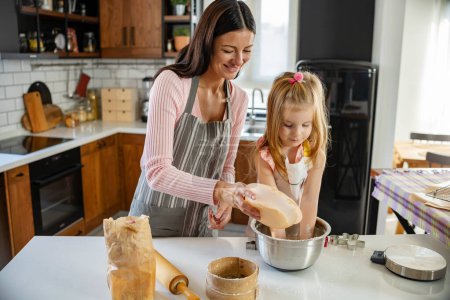 Téléchargez les photos : Mère et fille cuisinent ensemble à la maison - en image libre de droit