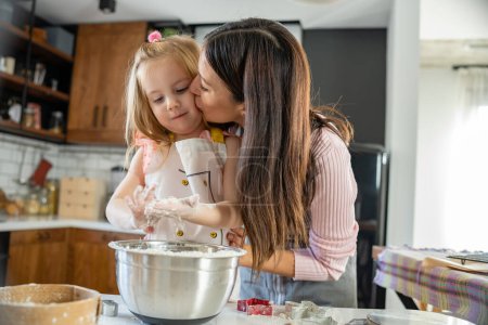 Téléchargez les photos : Mère et fille cuisinent ensemble à la maison - en image libre de droit
