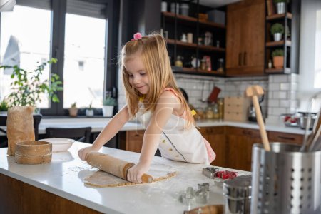 Photo for Little girl preparing dough at kitchen - Royalty Free Image