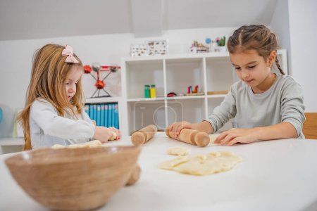Photo for Teacher with children in a Kindergarten Classroom cooking. Healthy learning environment. Kindergarten teacher, building relationships with the kids. Cheerful preschool children - Royalty Free Image