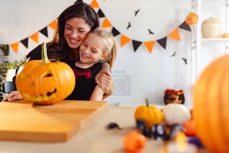 Foto de Madre e hija preparándose para halloween linterna de calabaza tallada - Imagen libre de derechos