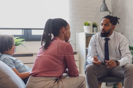 Photo for African American woman with a teen son has a meeting with a psychologist. A psychotherapist session with a patient. mother seeks professional help for her teenage son - Royalty Free Image