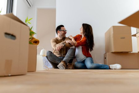 Photo for Young beautiful couple man and pregnant woman moving at new apartment - Royalty Free Image