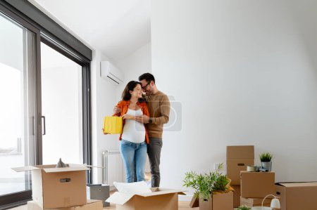 Téléchargez les photos : Jeune beau couple homme et femme enceinte déménageant dans un nouvel appartement - en image libre de droit