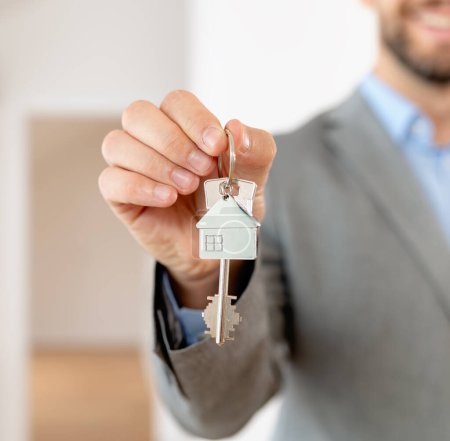 Foto de El agente de bienes raíces tiene una llave de una propiedad. Comprando un apartamento. Concepto inmobiliario e hipotecario. - Imagen libre de derechos