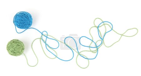 Téléchargez les photos : Boules de fil de coton colorées isolées sur fond blanc. Lignes de fil abstraites et deux boules de roulement bleues et vertes. - en image libre de droit